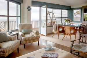 a living room with a table and chairs at Wishome-La casa más especial de Oyambre, Comillas in San Vicente de la Barquera