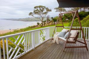 a porch with a swing and a view of the beach at Wishome-La casa más especial de Oyambre, Comillas in San Vicente de la Barquera +16 photos