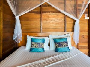 a bedroom with a bed with two blue pillows at Lipe Beach Resort in Ko Lipe
