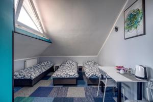 Pokój z łóżkami, stołem i oknem w obiekcie Noclegi pokoje gościnne Żeglarz w mieście Gdynia