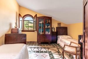1 dormitorio con 2 camas, armario y ventana en Casa Bizzarro, en Deliceto