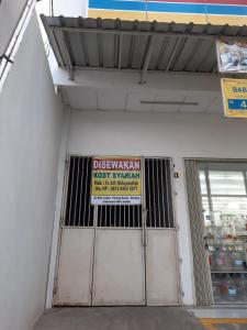 uma porta de uma loja com um sinal sobre ela em uma loja em OYO Life 92781 Kost Parung Serab Syariah em Tangerang