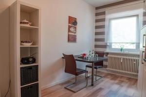 d'une salle à manger avec une table, des chaises et une fenêtre. dans l'établissement Ferienwohnung Bonnie und Kleid, à Sarrebourg