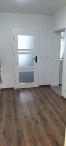 um quarto vazio com uma porta e pisos em madeira em Kawalerka blisko GÓR em Głuchołazy