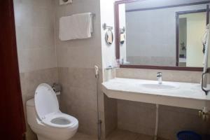 bagno con servizi igienici, lavandino e specchio di Uni Resort a Cox's Bazar