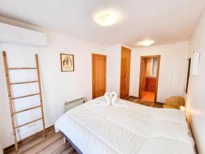 - une chambre avec un lit blanc et une échelle dans l'établissement Aguadores del Pilar ComoTuCasa, à Saragosse