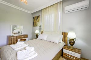 1 dormitorio con 1 cama con sábanas blancas y ventana en Vacation Oasis in Antalya 5 min to Lara Beach, en Antalya