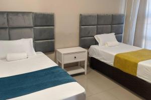 a bedroom with two beds and a nightstand between them at Holiday Haven in Gaborone
