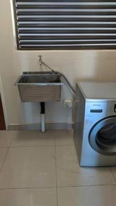 a kitchen with a sink and a washing machine at Holiday Haven in Gaborone
