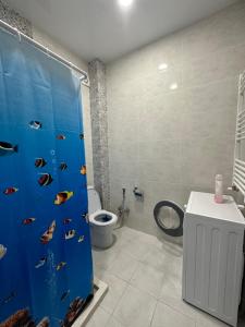 un baño con una cortina de ducha azul con pescado. en Guesthouse Chrdili, en Tiflis
