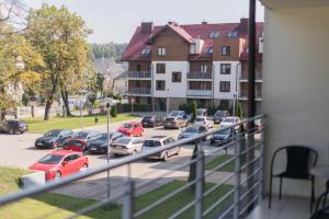 een uitzicht op een parkeerplaats met geparkeerde auto's bij Apartament Pełen Wdzięku z balkonem in Polanica-Zdrój