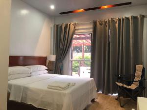 1 dormitorio con 1 cama y una ventana con cortinas en Melbas Homestyle Resort & SPA, en Santander