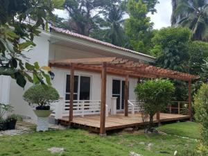 una casa con terraza de madera en el patio en Melbas Homestyle Resort & SPA, en Santander