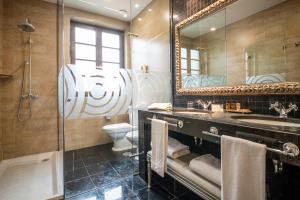 W łazience znajduje się umywalka, toaleta i lustro. w obiekcie Gran Hotel Las Caldas by blau hotels w mieście Las Caldas