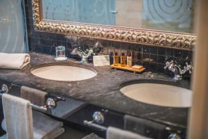 a bathroom with two sinks and a mirror at Gran Hotel Las Caldas by blau hotels in Las Caldas