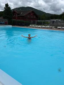 une personne nageant dans une grande piscine dans l'établissement First Camp Bø - Telemark, à Bø