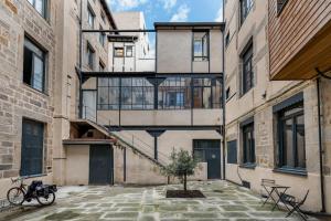 un edificio con una escalera y un árbol en un patio en Zeus loft 400m² 6rms 6BR hypercentre, en Saint-Étienne