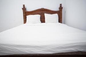 uma grande cama branca com duas almofadas em OYO Life 92886 Rumah Nyaman Radhika 2 Syariah em Tuban