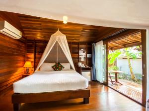 a bedroom with a bed with a mosquito net at Lipe Beach Resort in Ko Lipe