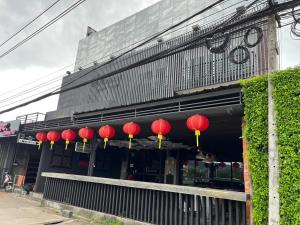 una fila di lanterne rosse nella parte anteriore di un edificio di Bell Lifestyle Hostel Phuket a Nai Yang Beach