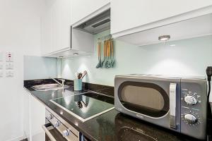 a kitchen with a microwave and a sink at Serene Escape in Covent Garden in London