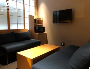 uma sala de estar com um sofá e uma mesa de centro em ALPHABED INN Takamatsuekimae em Takamatsu