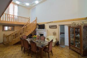 ein Esszimmer mit Tisch und Stühlen und eine Treppe in der Unterkunft Rezo's Ranch in Samtredia