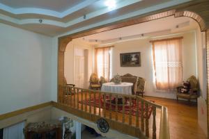 ein Wohnzimmer mit Tisch und Balkon in der Unterkunft Rezo's Ranch in Samtredia
