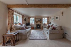 a living room with two couches and a table at Traditional Cotswold Stone Peaceful Cottage with stunning views in Stroud
