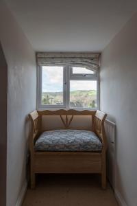 Habitación pequeña con cama frente a una ventana en Traditional Cotswold Stone Peaceful Cottage with stunning views, en Stroud