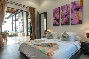 1 dormitorio con 1 cama grande con flores en la pared en Villa Sheeba, en Pengastulan