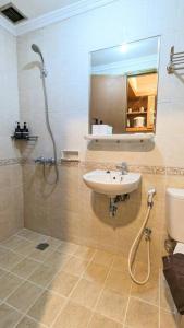 een badkamer met een wastafel, een douche en een toilet bij Cottonwood Japandi Apartment at Majesty 509 in Bandung