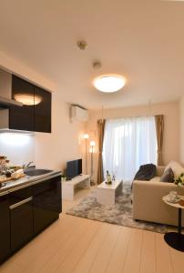 a kitchen and a living room with a couch at FL Residence Todai II in Tokyo