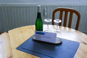 a bottle of wine and a laptop on a table at Ferienwohnung Berggarten in Saarburg