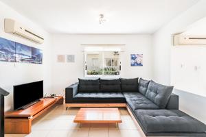 a living room with a couch and a tv at Villa Alysia by Ezoria Villas in Coral Bay