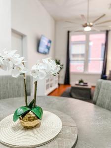 a vase with white flowers sitting on a table at Gaslamp 2bdrm - W Parking & 5 Beds #303 in San Diego