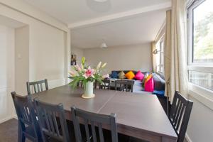 a dining room table with chairs and a vase of flowers at ALTIDO Spacious apt with private yard in Notting Hill in London