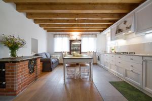 a kitchen with white cabinets and a table in a room at Casa Sittaro in Grimacco