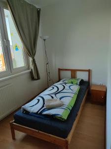 a bed sitting in a room with a window at Fast Apartment close by centrum in Levice