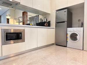 eine Küche mit Waschmaschine und Waschmaschine in der Unterkunft Soho Suites KLCC By Grand Suites KL in Kuala Lumpur