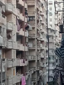 um edifício de apartamentos alto com roupas penduradas nas varandas em فيروزة ميامي إطلالة على البحر عائلات فقط أو رجال فقط em Alexandria