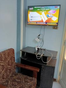 um quarto com uma cadeira, uma televisão e um piano em فيروزة ميامي إطلالة على البحر عائلات فقط أو رجال فقط em Alexandria