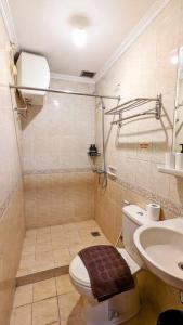 a bathroom with a toilet and a sink at Cottonwood Country Apartment at Majesty 715 in Bandung