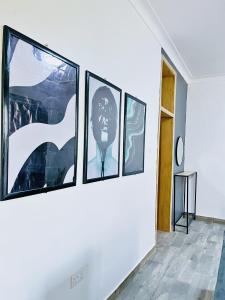 a group of four pictures hanging on a wall at Apartment unit- Urban chills in Bulindo