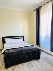 a bedroom with a large bed with a window at Apartment unit- Urban chills in Bulindo
