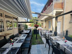 a restaurant with tables and chairs in a patio at Parkhotel Gent Centrum in Ghent