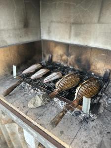 a bunch of hot dogs cooking on a grill at Apartmani Krolo Trogir otok Čiovo in Trogir