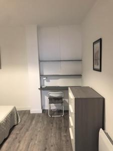a bedroom with a desk and a chair in it at Appartement climatisé Barjac centre ville in Barjac