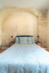 ein Schlafzimmer mit einem blauen Bett und zwei Nachttischen in der Unterkunft SplendideT2 centre ville & terrasse extérieure in Cognac
