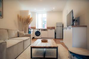 ein Wohnzimmer mit Sofa und Tisch in der Unterkunft SplendideT2 centre ville & terrasse extérieure in Cognac